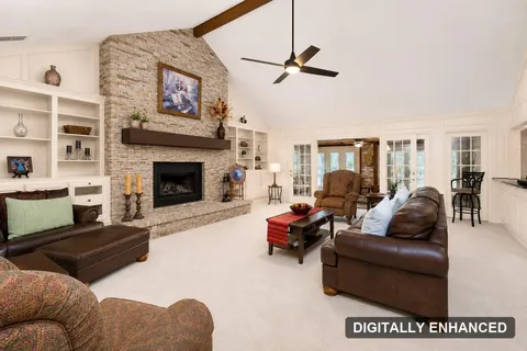 Family room with vaulted ceiling and stone fireplace, digitally enhanced (digitally enhanced)