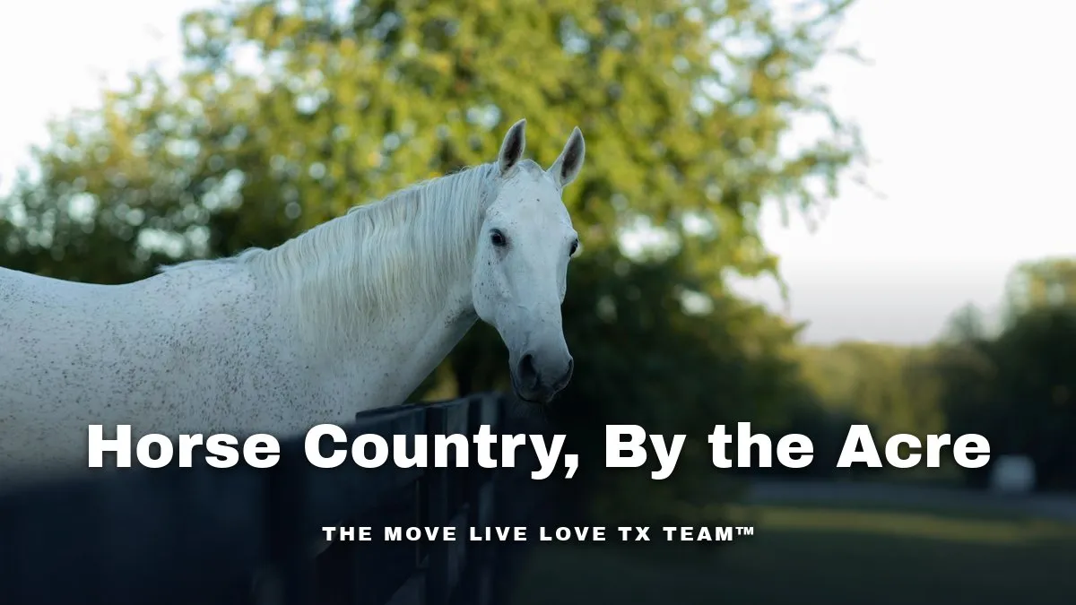 A white three-rail fence around a green pasture with horses grazing in front of a Texas ranch-style estate home at sunrise
