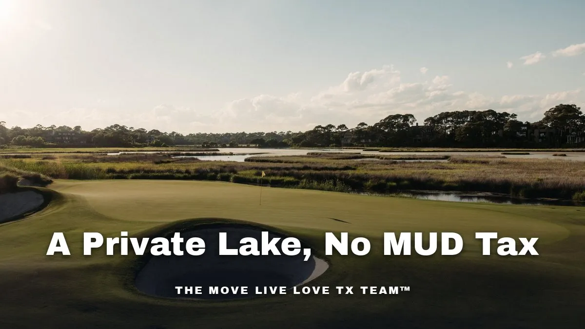 A private lake framed by large brick homes and mature trees under a bright morning sky in a Texas golf course community